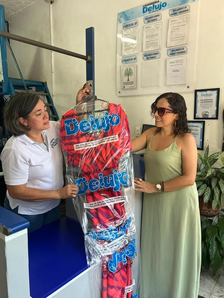 Una integrante del equipo entregando una prenda empacada a una clienta